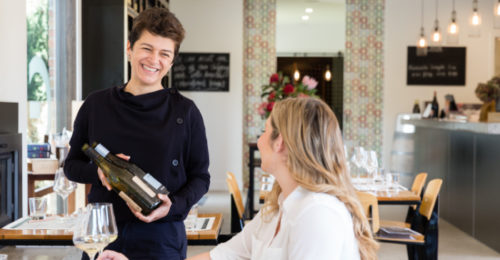 waitress presenting bottle to customer